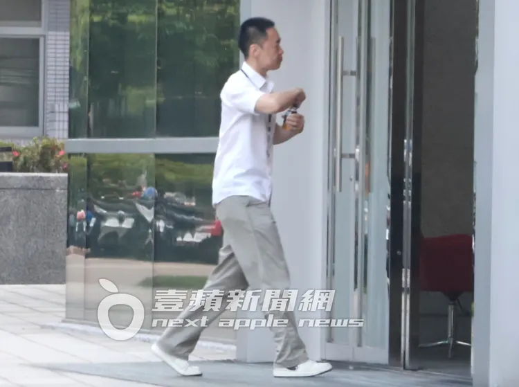 張承中送友人上計程車後，到便利商店買咖啡，走回附近商辦大樓。特勤中心攝