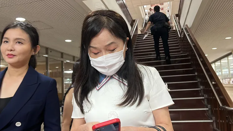 周玉蔻開完庭未理會記者提問，低頭滑手機。陳彩玲攝