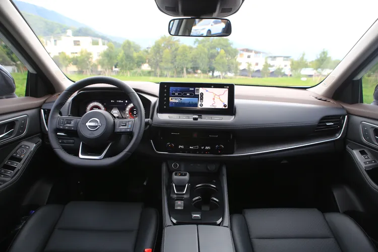 X-Trail輕油電車艙在配色上以黑色為主要基調，中控台在中高階車款上覆有軟質皮革，搭配深色木紋飾板、平把式方向盤，整體質感仍有一定水準。林浩昇攝