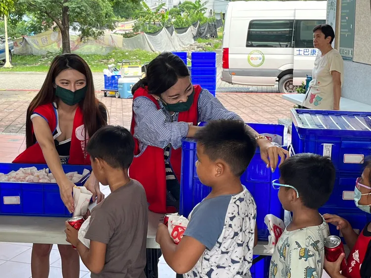 主播小葡萄（左）發送物資給學童。翻攝畫面