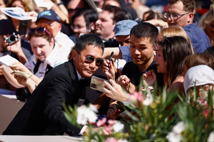 梁朝偉被邀請合照簽名都親切答應。路透社