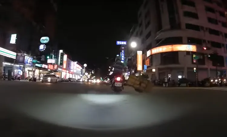 機車騎士後方綁著一台手推車，疾駛在高雄市區， 左右搖晃。翻攝畫面