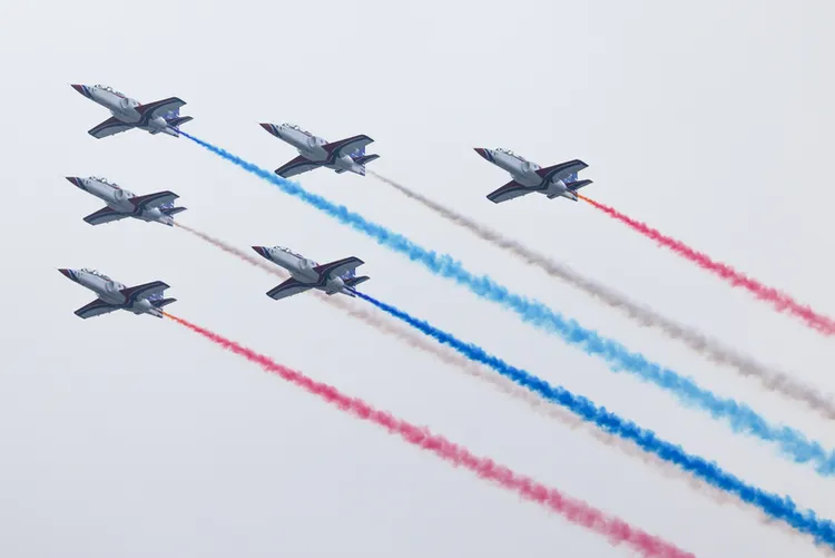 國軍28日展開空中全兵力預演，6架 AT-3教練機施放彩煙飛越北市上空。 中央社