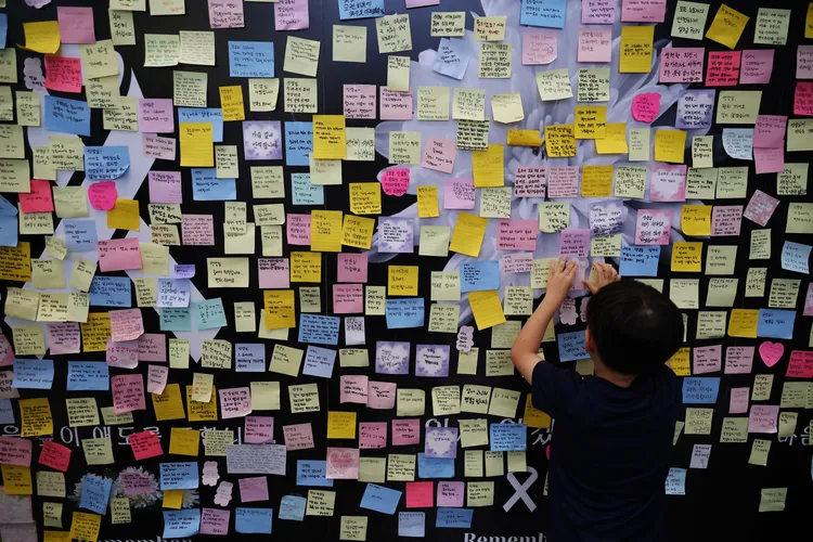 女教師任職的學校設置留言牆，讓師生貼紙條悼念亡者。路透社