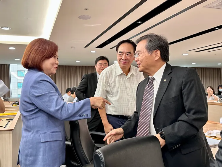 許銘春和代表資方的基本工資審議委員寒暄。王良博攝