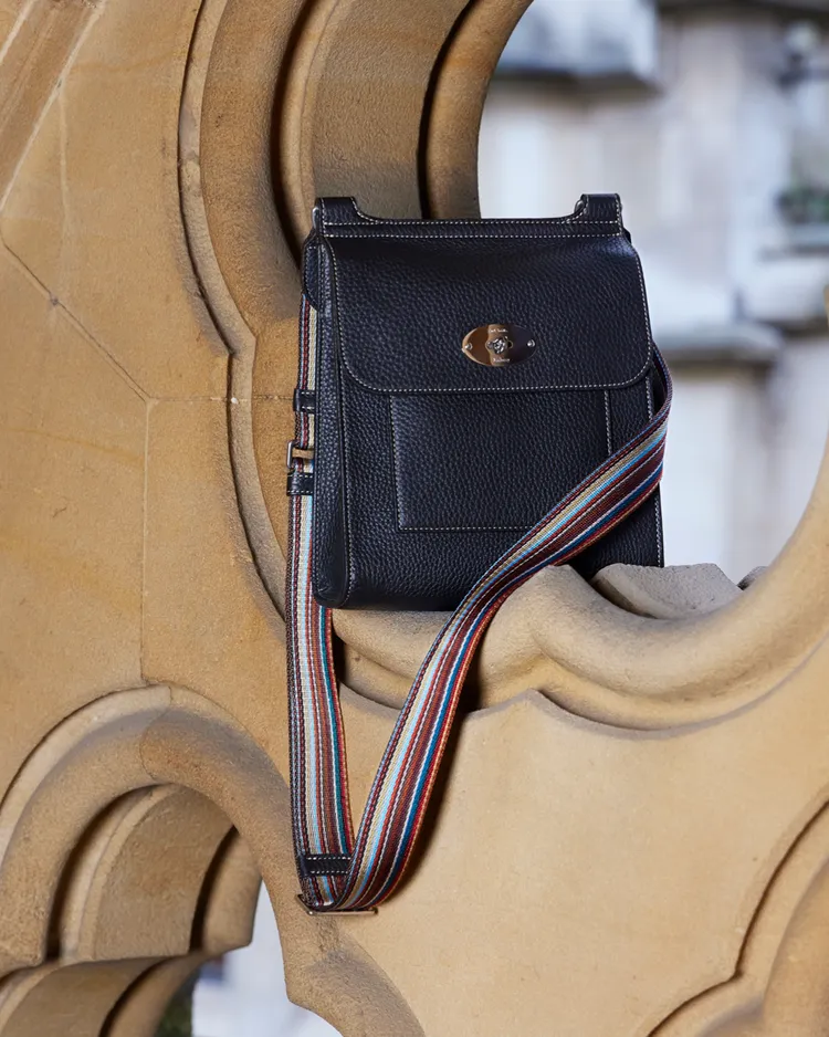 黑色荔枝紋牛皮搭配彩色條紋織背帶詮釋出低調優雅的系列包款。品牌提供