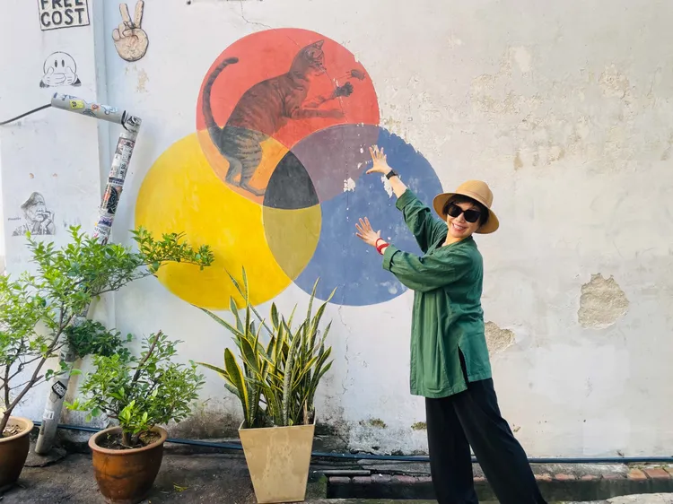 唐美雲(左)和從吉隆坡過來檳城的劇團志工-張綠蕾(右) 一起跟壁畫拍照。唐美雲歌仔戲提供