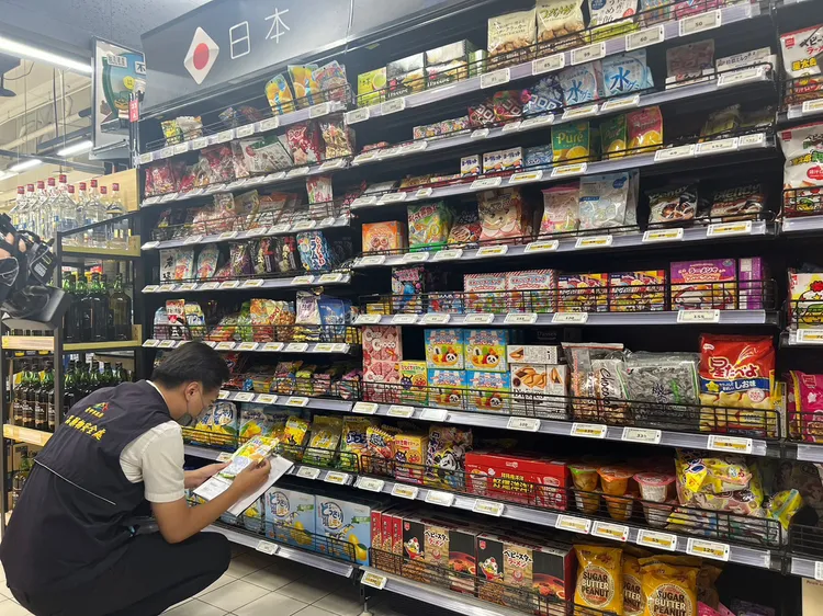 市府人員檢視貨架上的食品標示是否完整。市府提供