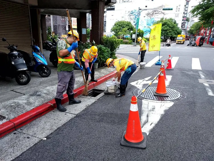 清潔隊員颱風前忙清側溝。北市環保局提供