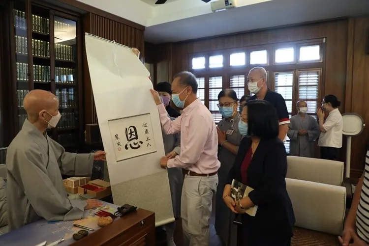 新加坡前外交部長楊榮文（中）以親筆寫的「恩」字，向證嚴法師表達感恩。花蓮慈濟醫院提供