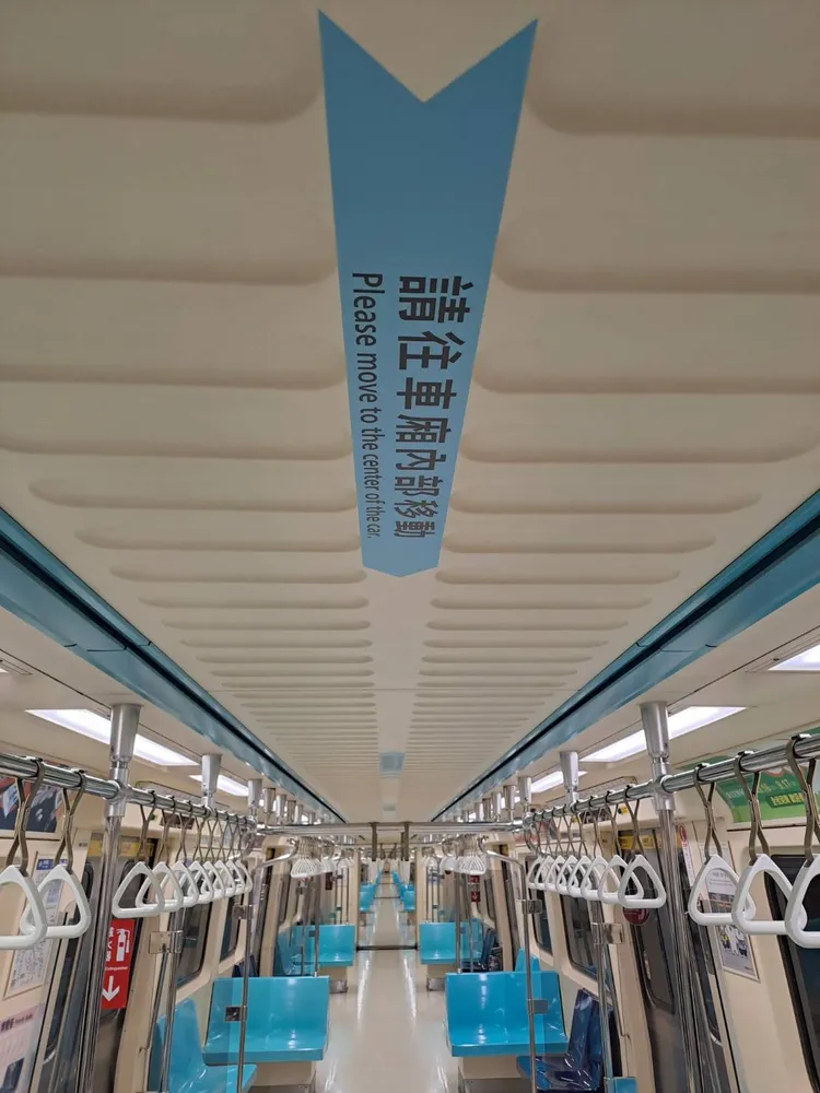車廂頂部及地板分別張貼「請往車廂內部移動」、「下車等候區」宣導指標，分流上下車旅客。北捷提供