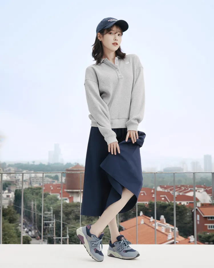 IU身穿NB ATHLETICS系列灰色長袖上衣與同系列的深藍色抽繩長裙。品牌提供
