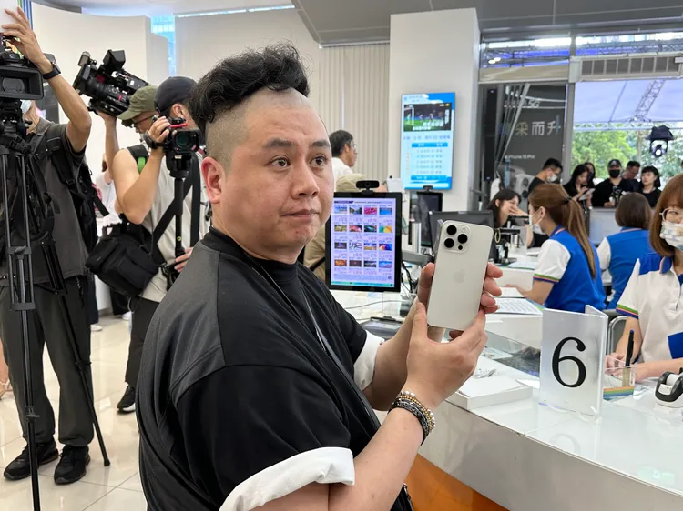 搶得中華電信「頭香」的許先生，展示拿到的新機。王良博攝