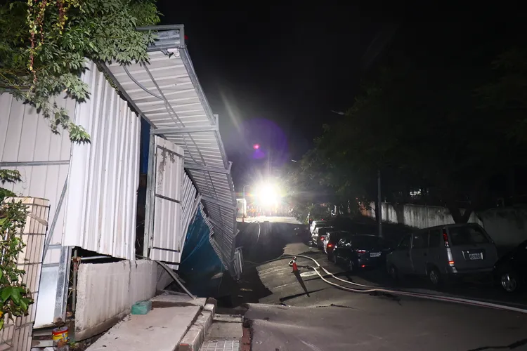 道路下陷讓停放的車輛受困其中。彭欣偉攝