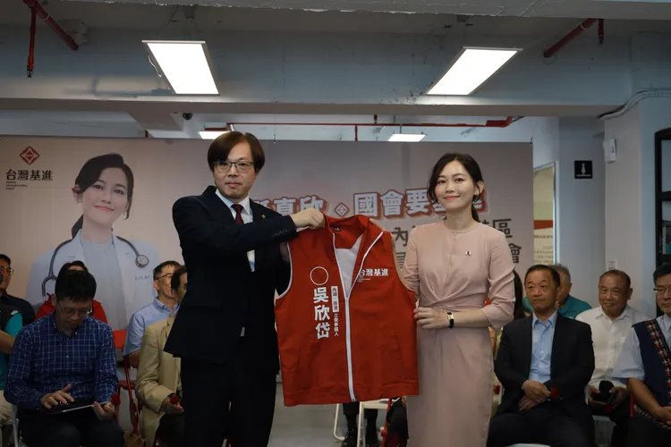吳欣岱從黨主席王興煥手中接下候選人背心戰袍。基進提供