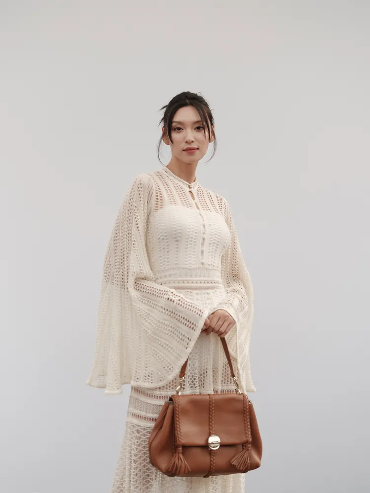 王丹妮身穿米色鏤空針織洋裝。品牌提供