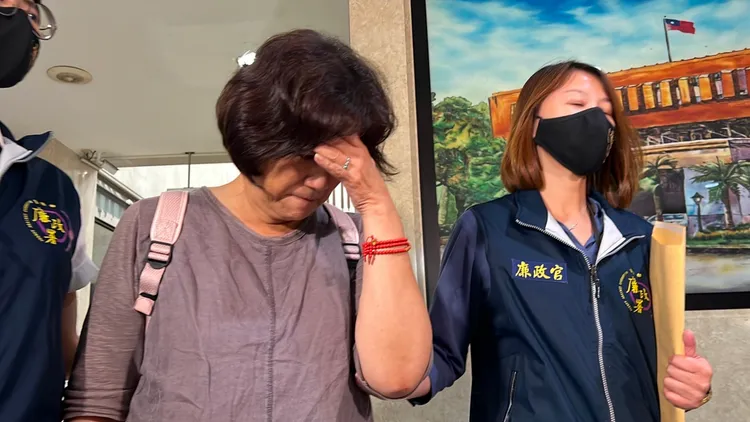 石妻(中)被廉政官帶到地檢署接受複訊。陳彩玲攝