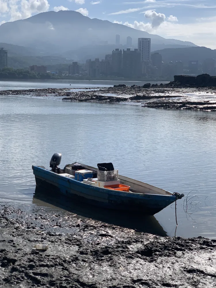 許男與朋友兩人划著私人小漁船到沙洲挖蛤蠣。翻攝畫面