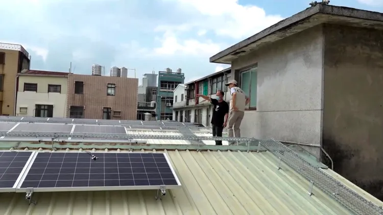 羅一鈞與一名工作人員先爬上屋頂。讀者提供