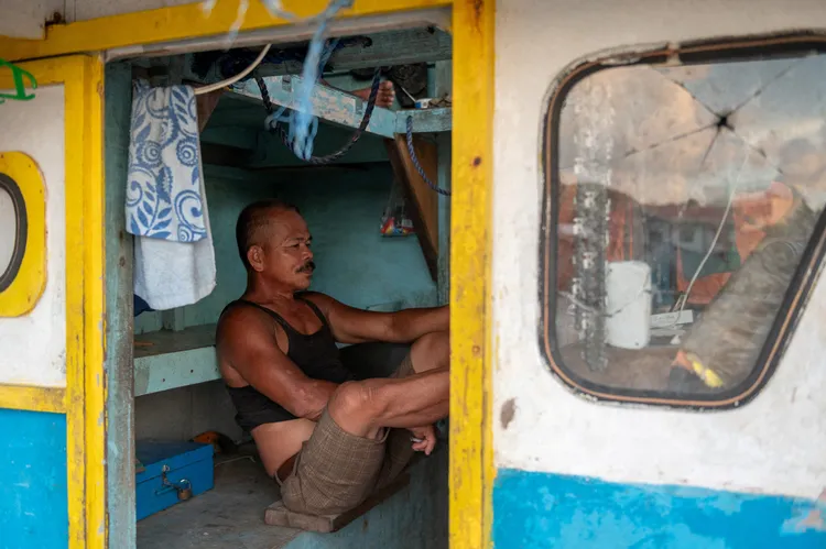 菲律賓漁三描禮士省港口漁船上的漁民。路透社