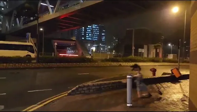 蘇拉風力太強，熱褲女不敵暴風倒地。取自影片截圖