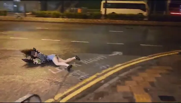 熱褲女被暴風吹跌，臉朝下滑出馬路。取自影片截圖