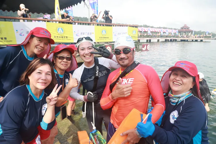 來自新北土城的李宜勳（中戴泳帽者），是第一位上岸的女性泳客。縣府提供