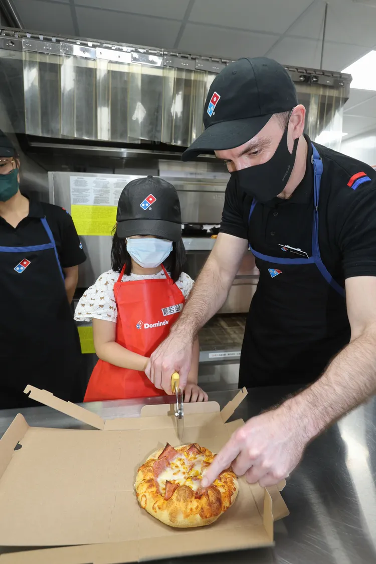 達美樂CEO教導小朋友如何切披薩。業者提供