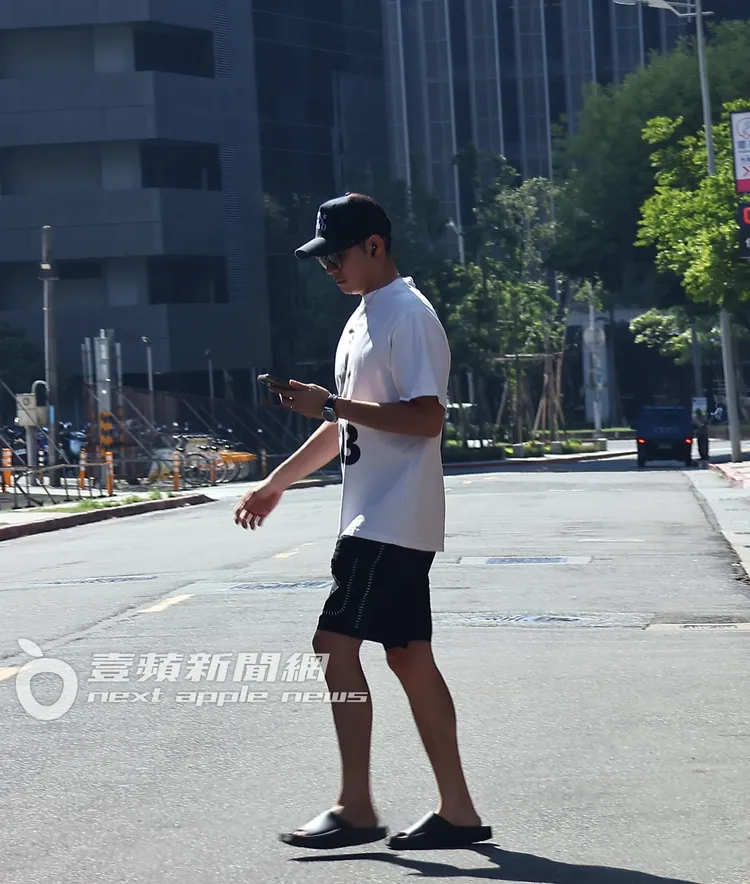 王柏傑一邊看著手機，一邊聽著音樂，穿越馬路未走斑馬線。特勤中心攝