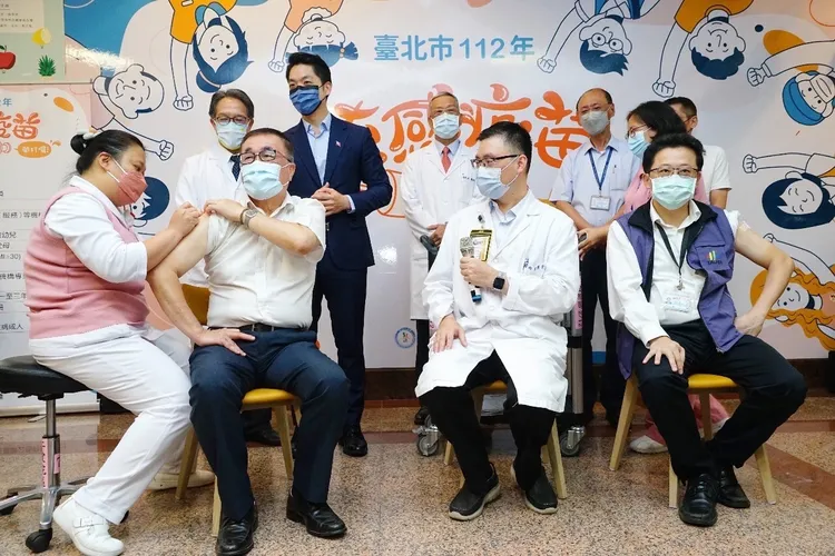 李四川(左2)帶頭開打公費流感疫苗。北市府提供