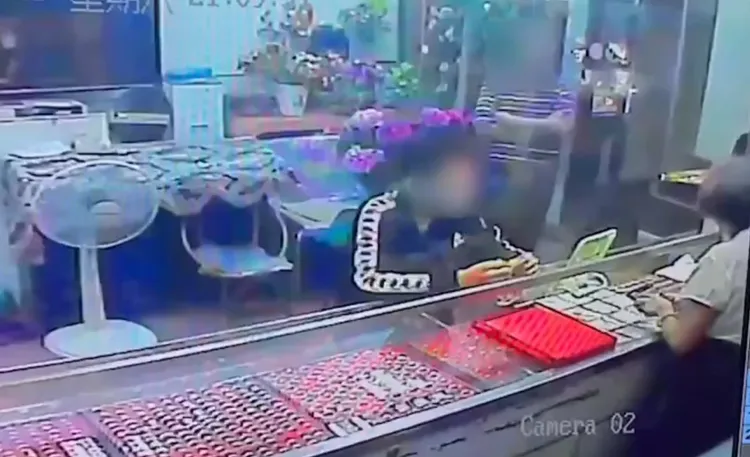 施男假裝看金飾卻拿了就跑。翻攝畫面