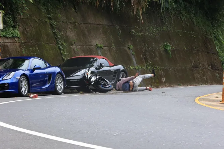 機車騎士跑山過彎失控，機車撞上停在路邊的保時捷。取自「重機車友 ❘ 各區路況天氣、資訊分享中心」