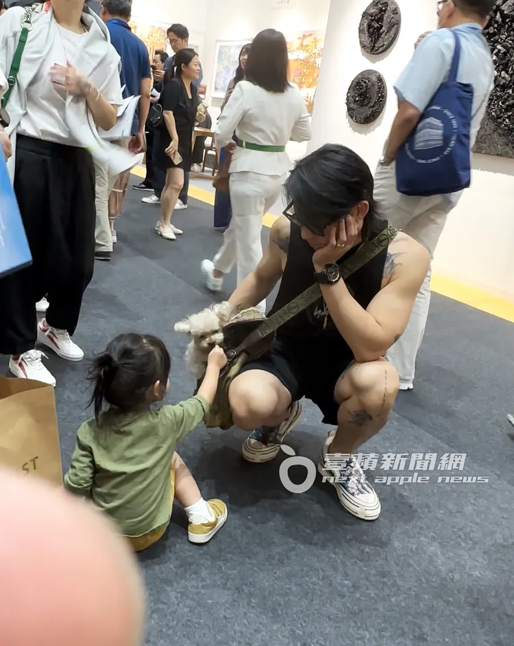 吳建豪蹲下和友人女兒與愛犬互動。特勤中心攝