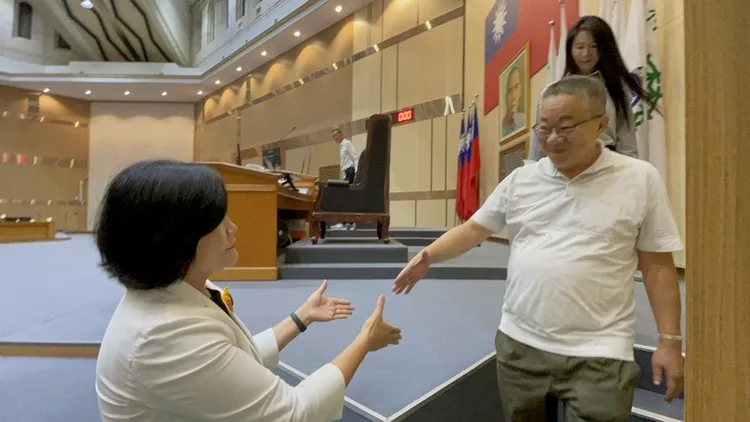 國民黨籍雲林縣議長沈宗隆（前右）13日主持議會時，宣布即刻請辭議長一職，隨後步下主席台，雲林
縣長張麗善（左）上前握手表達感謝。中央社