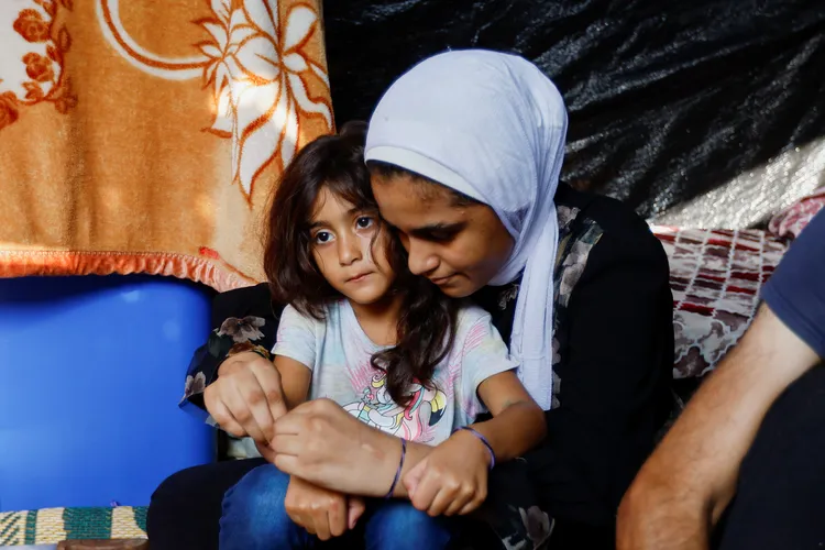 媽媽為女兒繫上手環。路透社