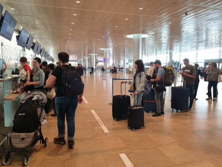 搭乘撤僑專機國人排隊辦理登機手續。外交部提供