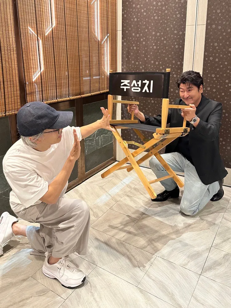 周星馳（左）、宋康昊逗趣拍照，導演椅上貼著韓文的周星馳。翻攝陳震宇Chris微博