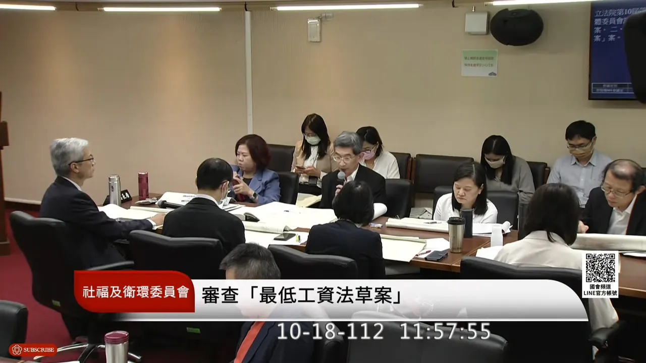 黃維琛(圖中持麥克風者)代表勞動部在會議中說明行政院版「最低工資法」草案內容。取自YouTube「國會頻道」