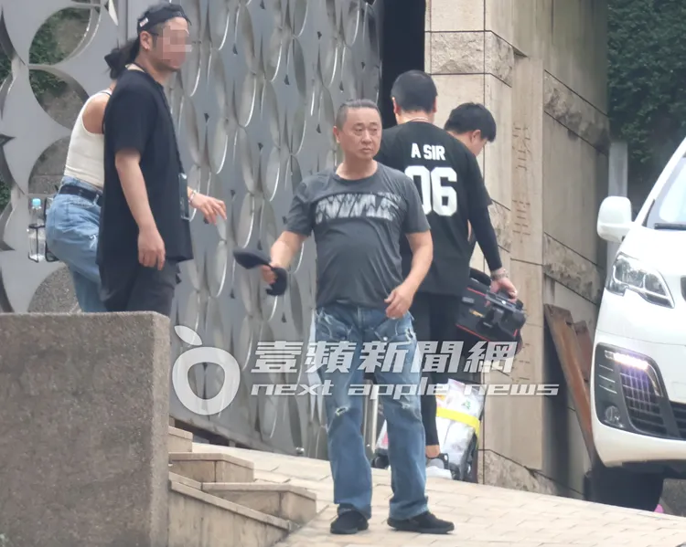 邰智源（中）換好衣服，跟工作人員準備搭乘寶獅旅行車離開。特勤中心攝