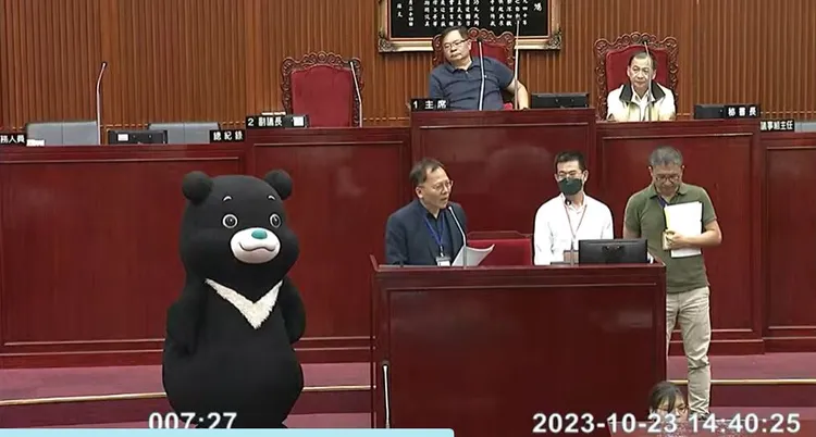 北市吉祥物熊讚今偕同觀傳局長王秋冬到議會備詢。翻攝議會直播畫面