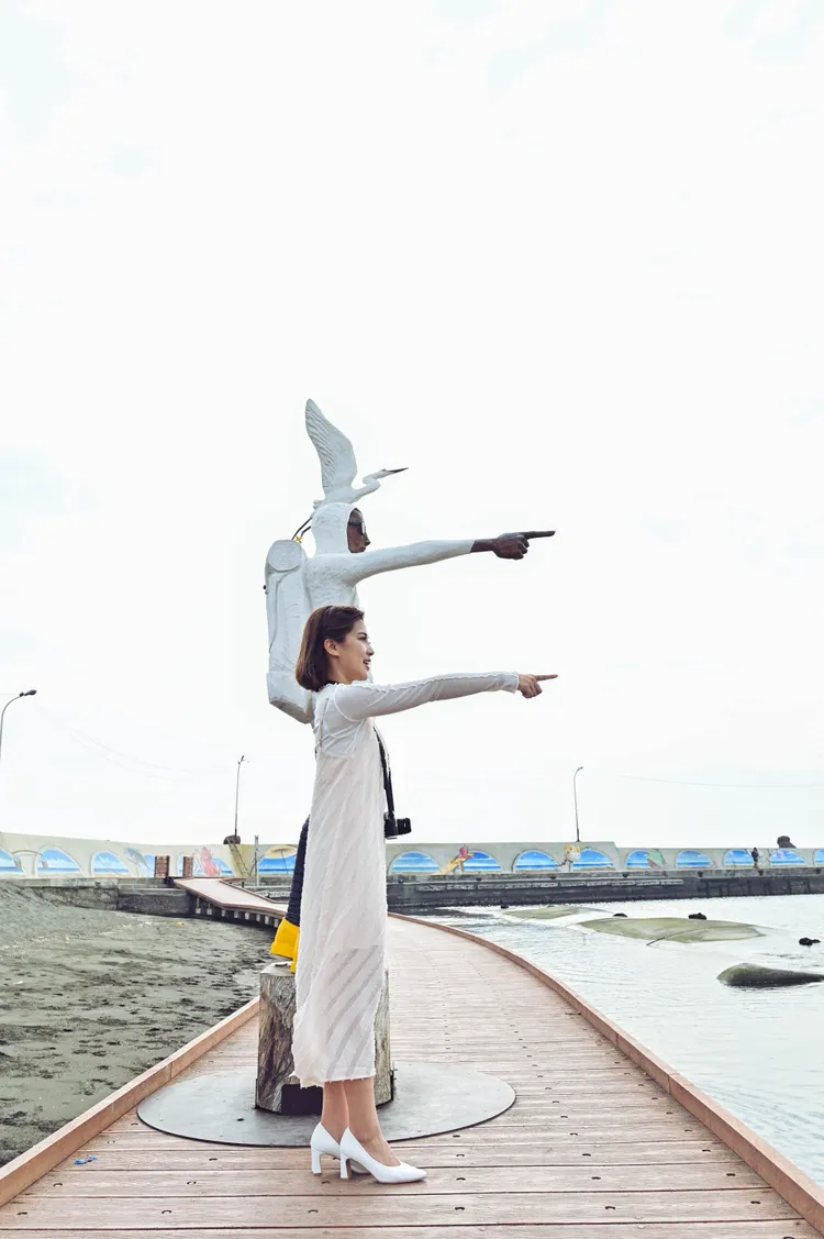 高市府發言人周璟瑜與「旅途之海」藝術作品合照，示範絕佳拍攝點簡單拍出自然網美風。海洋局提供