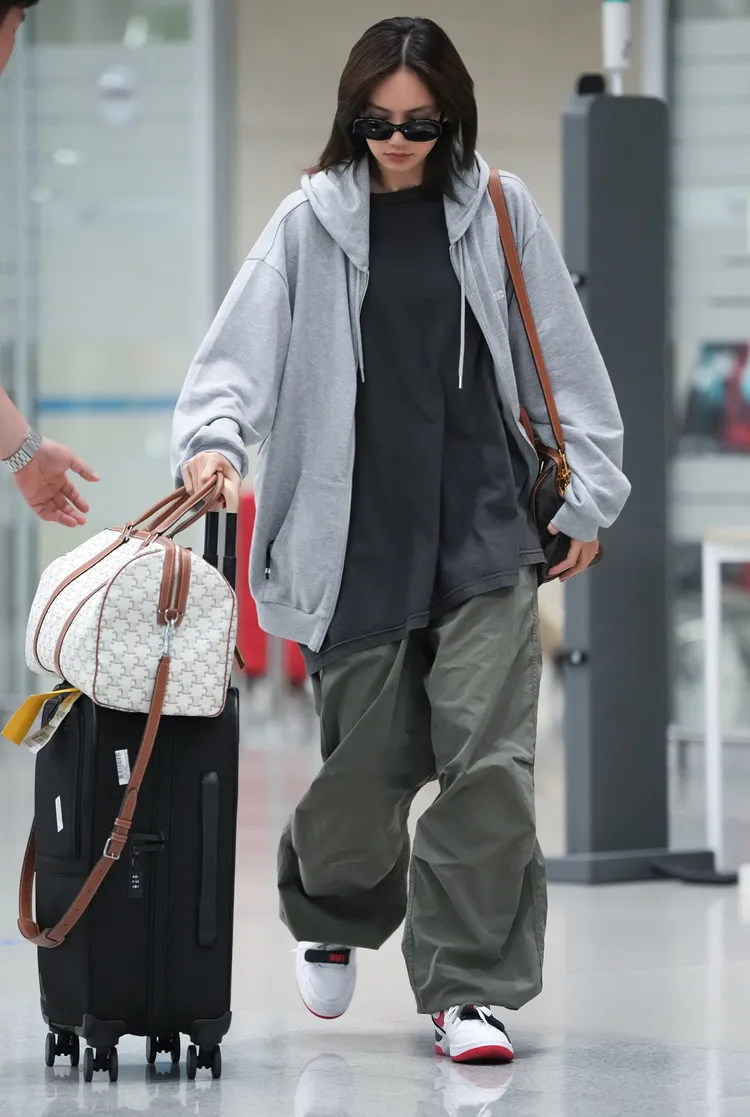 Lisa曾帶著白色Triomphe Canvas印花款中型旅行袋現身機場