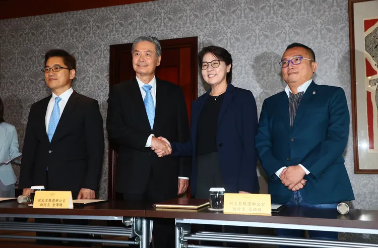 黃珊珊跟金溥聰在記者會上握手。彭欣偉攝