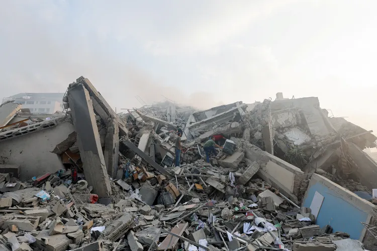 加薩居民在轟炸後的廢墟中，試圖尋找倖存的生還者。路透社
