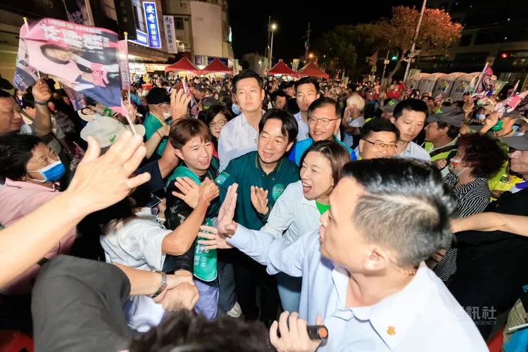 民進黨總統參選人賴清德（中綠色外套者）14日晚間在台中是出席爭取連任的同黨立委林靜儀（中右）造勢晚會，兩人進場時受到現場群眾熱情歡迎。中央社