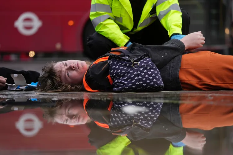 示威人士躺在地上，消極抵抗警方逮捕。美聯社