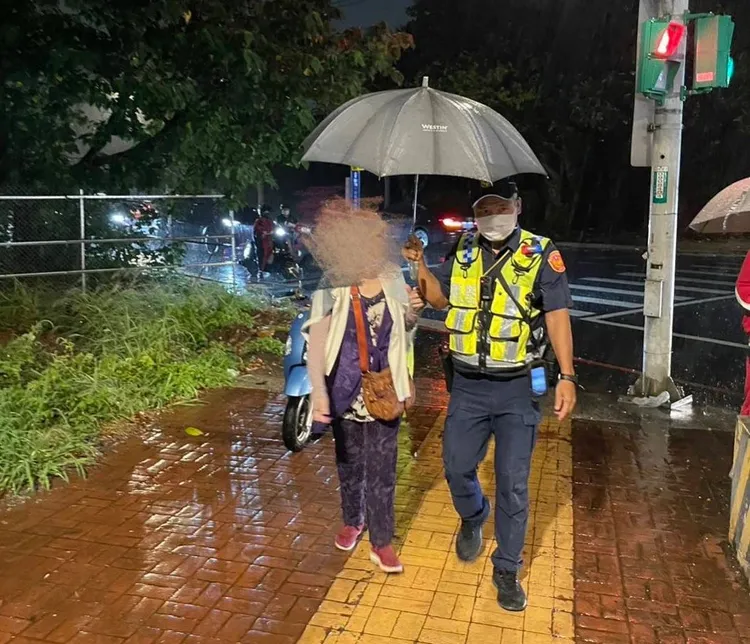 警員為老婦撐傘，免再淋濕。八德警分局提供