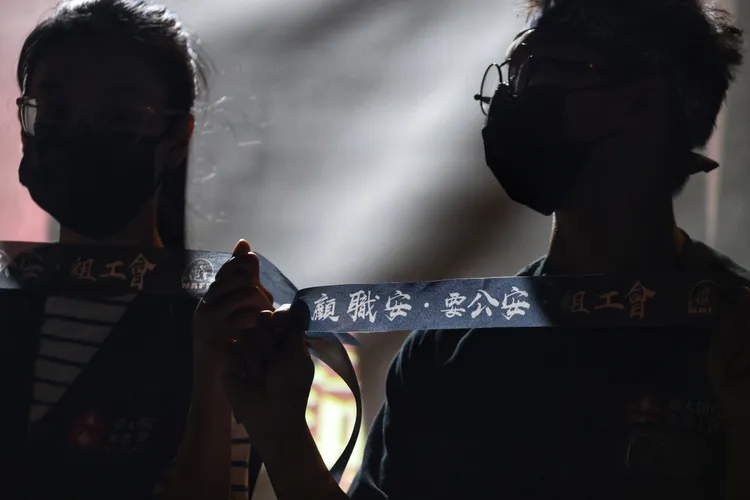 參加晚會的民眾手持寫有顧職安、要公安、組工會三大訴求字樣的頭帶悼念殉職消防員。林林攝