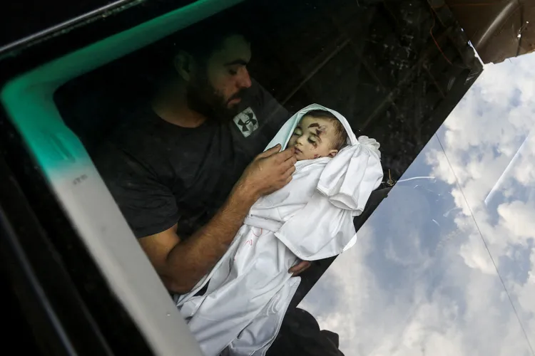 巴勒斯坦傷心的父親失魂落魄的看著已不幸殞命的嬰兒。路透社