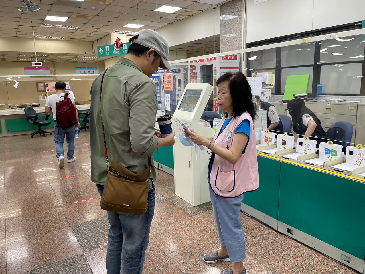 穿上志工背心，王雪梅依舊發揮昔日負責電話諮詢專線的工作精神，為民眾於現場解惑。翻攝畫面